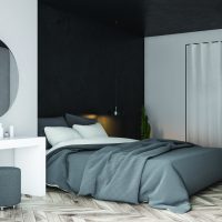 Corner of modern bedroom with white and black walls, wooden floor, gray master bed and white makeup table with round mirror above it. 3d rendering